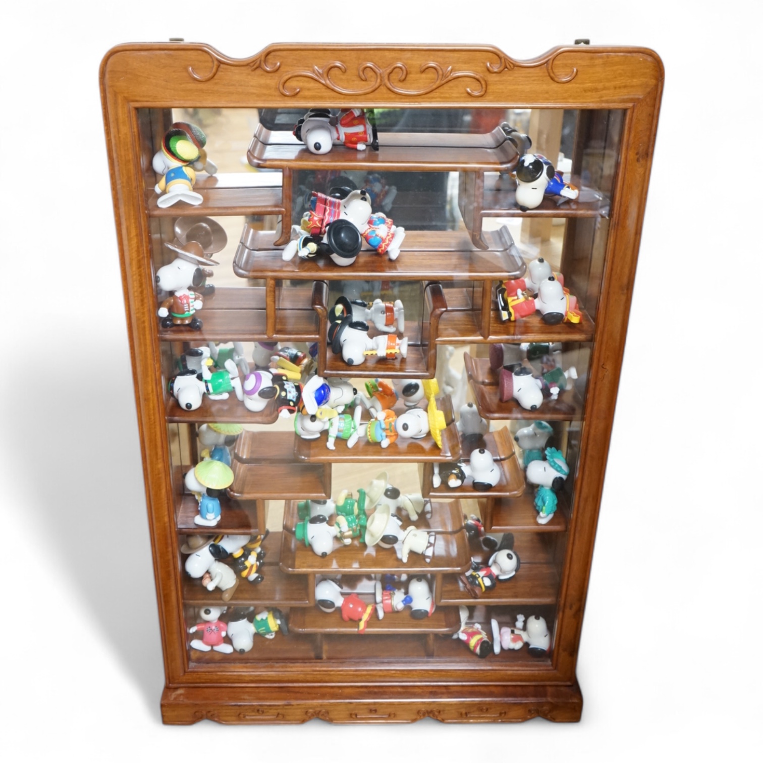 A Chinese padouk snuff bottle cabinet housing a collection of Snoopy figures, 81cm high. Condition - good